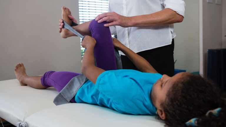 physiotherapist-assisting-girl-patient-in-performi-2026-01-09-09-17-36-utc